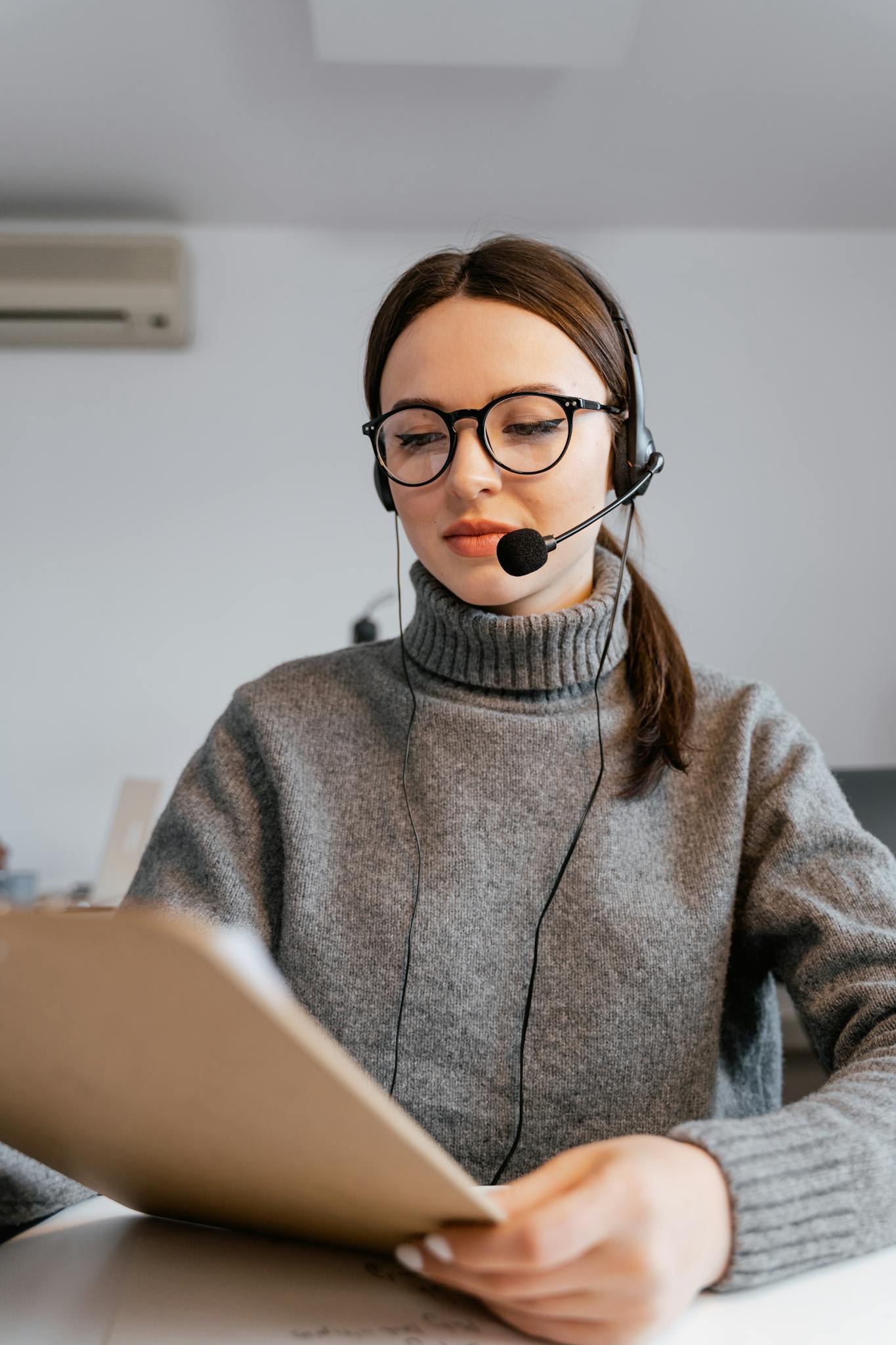 Professional woman in office with headset providing customer support.